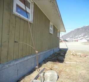 House in Pangnirtung with roof being held by metallic wires. Photo by Annalise Biedermann, June 2013.